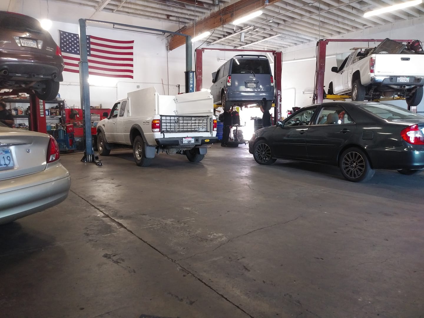 Vehicles and lifts inside Maya Smog and Repair